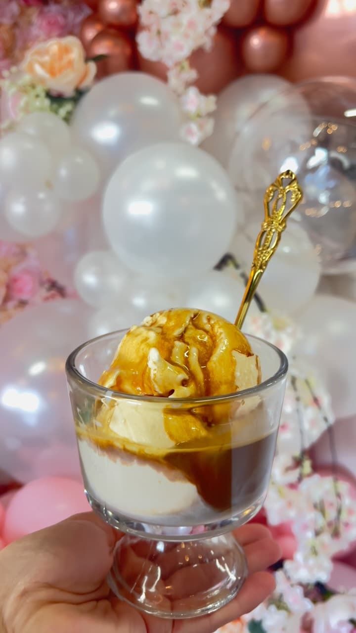 Espresso affogato in a stemmed glass against blush balloons.